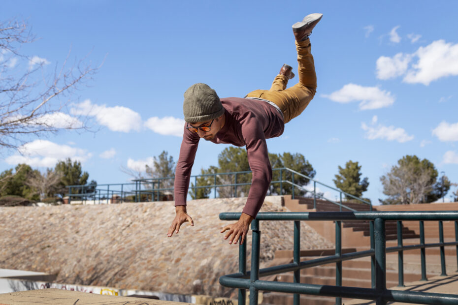 A man beginning his parkour practice by jumping outdoor location.