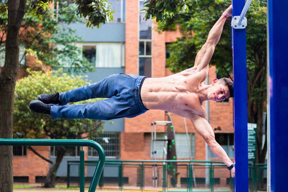 A guy practicing for parkour swings.