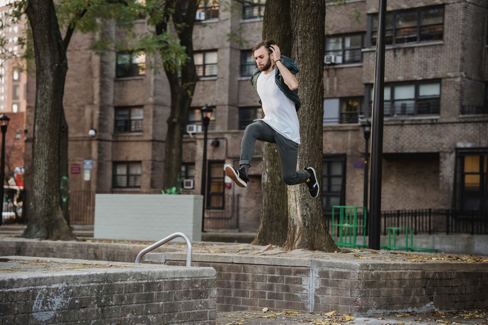 A traceur training in casual, loose-fitting clothing on a city street.