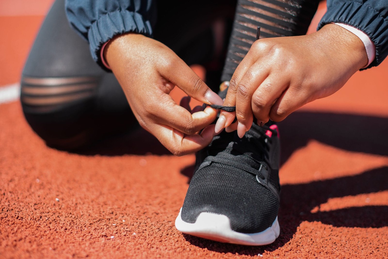 Close-up of an athlete tying their shoes, preparing for training.