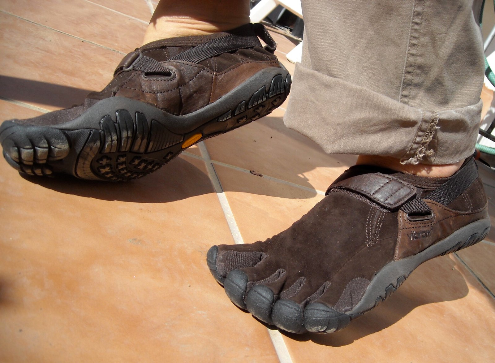 A pair of brown Vibram FiveFingers KSO toe shoes, showing the individual toe pockets and thin rubber sole.