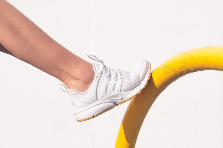 A trainer resting on a metal rail, the kind of contact that wears parkour soles.