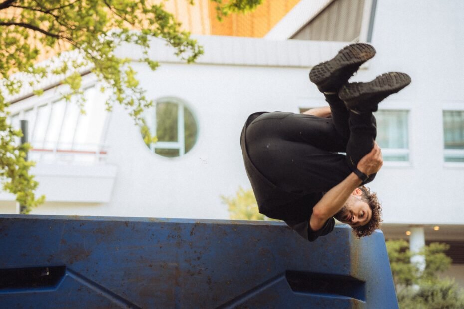 A freerunner performing a flip off an urban structure.