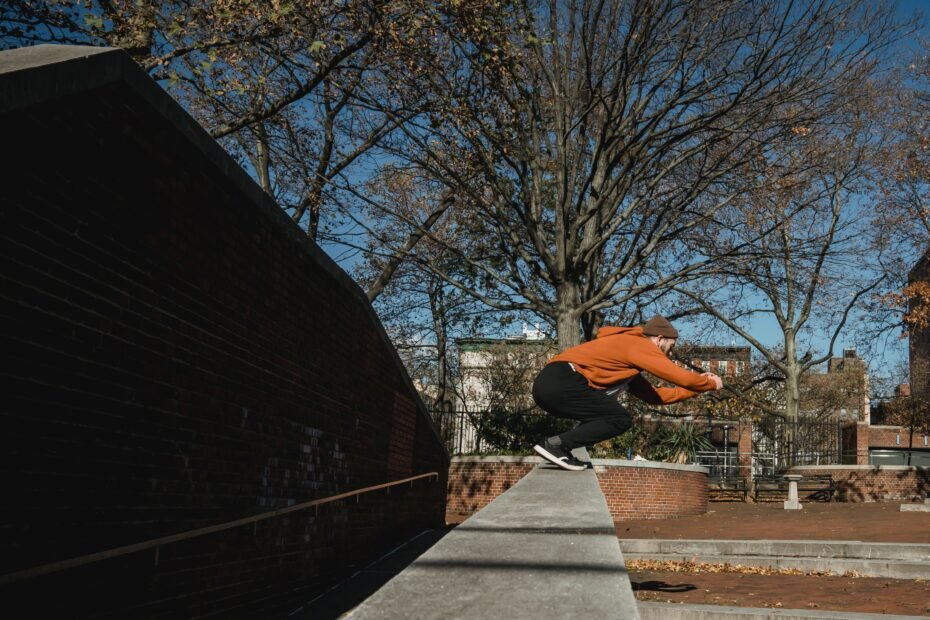 A traceur standing on a brick wall preparing to jump, hesitating before committing.